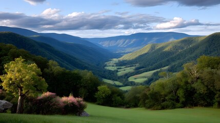 Obraz premium Serene Mountain Valley Landscape Breathtaking View of Rolling Hills and Lush Green Foliage under a Cloudy Sky
