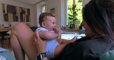 Mother playing with baby, holding child close in an affectionate and loving moment, with natural...