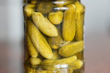Close-Up of Glass Jar Containing Fresh Pickled Gherkins on a Wooden Surface
