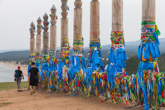 Lake Baikal in the summer. Tourists visit the sacred place on Cape Burkhan with 13 pillars, walk around them in the direction of the sun and tie colored ribbons. Summer travels and outdoor recreation