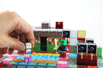 Fototapeta premium minecraft magnetic building toy blocks , from online virtual world game series are display on white table with many kinds of minecraft blocks , tnt magma stone wood grass water and cute characters