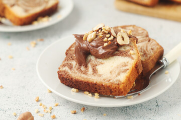 A piece of marble biscuit with chocolate cream and nuts	