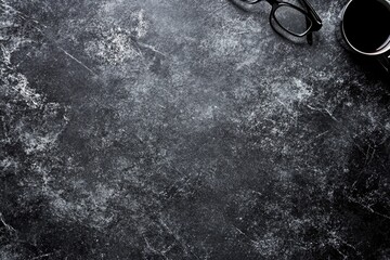 Dark gray stone surface with eyeglasses and coffee cup