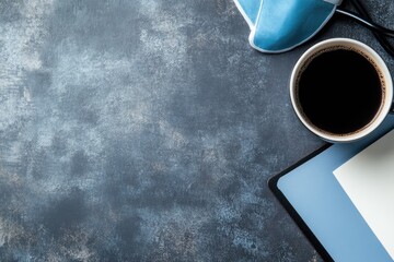 A flat lay of a workspace with a coffee cup, face mask, tablet and notebook
