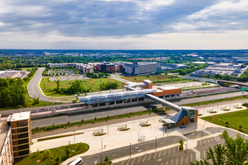 Above-ground subway station in Washington suburbs. Highways, parks and bus stops. Drone view.
