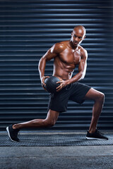 Obraz premium Male athlete, workout and lunges with medicine ball for sports, exercise and fitness in gym. Healthy man, topless and cardio routine for wellness, muscle and strength training for mental wellbeing