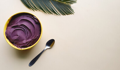 
creamy chilled açaí with texture in a yellow bowl and light beige background with space for text