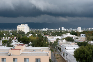 Fototapeta premium urban sprawl in mexico under dramatic storm clouds showcasing stark contrasts