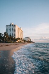 serene beachfront hotel with waves lapping shore sun highlighting architecture emphasizing tranquility