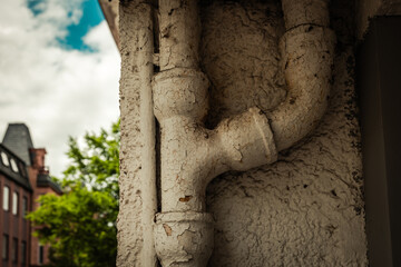 Rustic water pipe details contrasted against a vibrant sky and greenery capture urban charm in an...