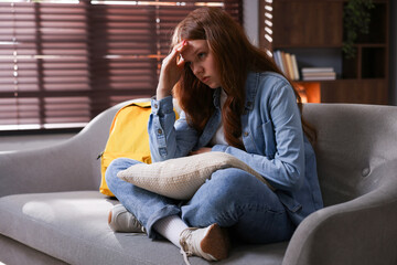 Obraz premium Sad teenage girl on sofa at home