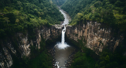 Waterfall Plunging into a Deep Rocky Gorge Surrounded by Green Forest