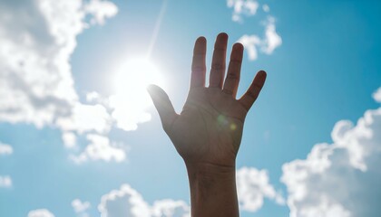 Hand reaching for the sun against a bright blue sky with fluffy white clouds.  A hopeful, optimistic image.