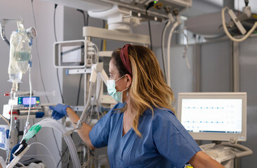 Doctor managing ventilator settings in intensive care unit