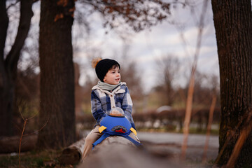 Smiling Child Balancing on Log with Rocket Backpack