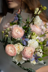 Young caucasian female holding bouquet of pink and white flowers with purple accents