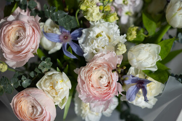 Elegant floral bouquet with pink ranunculus and white roses in soft daylight