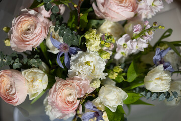 Spring bouquet with pink ranunculus, white roses and purple clematis
