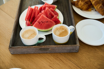 Healthy Breakfast Spread with Fresh Watermelon, Coffee, and Croissants