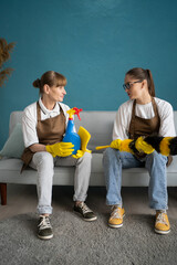Two Female Janitors Sitting on Sofa Resting and Talking After Cleaning