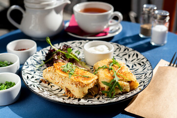 Fried sesame croquettes on pancake batter with Greek jogurt. Served on a white plate. A fresh and tasty breakfast set illuminated by the morning sun.