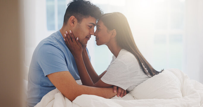 Couple, forehead and love in bed together, affection and bonding with commitment for trust at home. Romance, partner and security in healthy relationship with calm and interracial people in bedroom