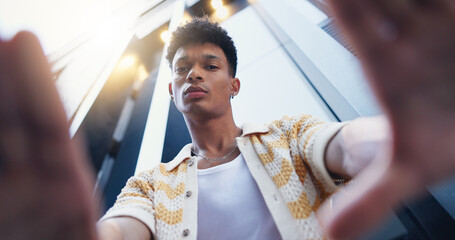 Fashion, frame and portrait of man in city with confidence for style, trendy and outfit. Low angle, perspective and selfie of person in urban town for creative, aesthetic and picture for photography