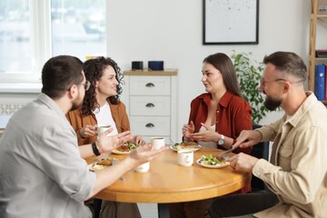Colleagues chatting during lunch break in office