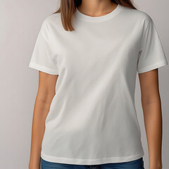 A woman is wearing a white t-shirt, standing in a neutral position. The t-shirt has a simple, clean design with short sleeves and is paired with blue jeans.