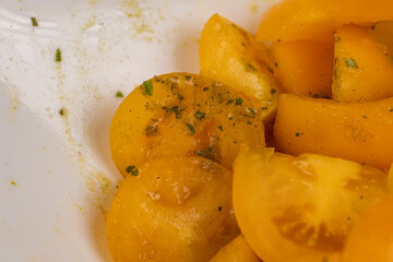 clean washed tomatoes are cut into pieces for cooking salad with spices and oil