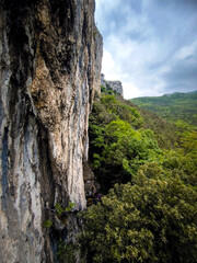 View on The Nago Climbing Base Camp In Italy, Overlooking Lush Green Forests And Rocky Cliffs