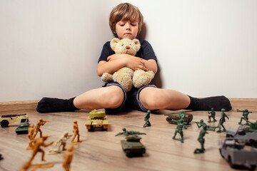 
The child huddled in a corner with a teddy bear and was afraid of soldiers. The child, as the main...