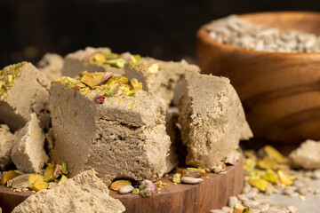 halva from sunflower seeds and crushed into one solid mass, a sweet delicious dessert made from seeds with pistachios, side view