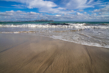 Mediterranean beach on the island of Majorca, or Mallorca on Balearic Sea, are part of Spain. Island in the Mediterranean Sea. Seaside vacations, clouds, seascape. View of the sea and the island.  