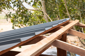 Roof under construction consist of brown wood structure frame both purlin and rafter, dark gray...