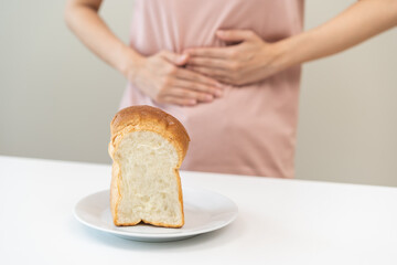 Gluten allergy, asian young woman, girl having a stomach ache hand holding, refusing to eat white...