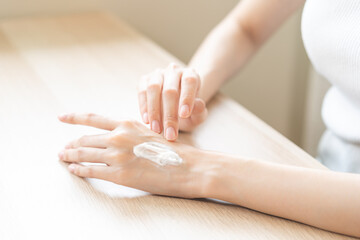 Healthy skin care, beauty asian young woman hand applying moisturizer, putting cream treatment on back hand after shower bath at home, makeup routine in the morning, treatment skin care body concept.
