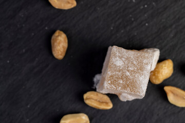 one oriental sweet Turkish delight with peanuts on a board, closeup