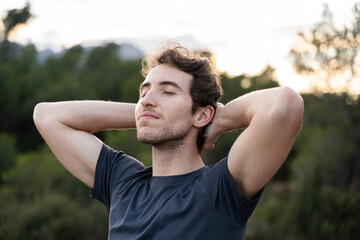 A man breathes fresh air in nature. Healthy lifestyle and emotional well-being.