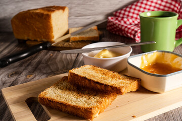Toasted sliced bread with butter and apricot jam for breakfast