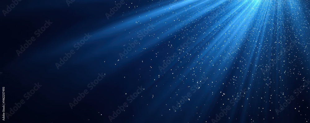 Poster sunbeams stream through water, illuminating floating particles against a deep blue background.