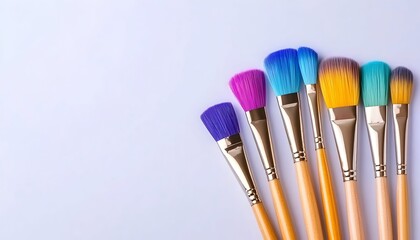 Colorful paintbrushes arranged on a light purple background