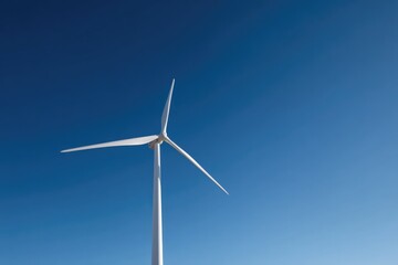 lone wind turbine standing tall against cloudless blue sky its blades catching gentle sunlight representing renewable