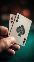 The hand of a person holding a pair of aces, a lucky poker card combination.