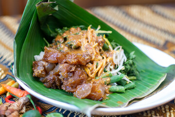 Indonesian vegetable salad with peanut sauce or pecel with koyor on banana leaf pincuk