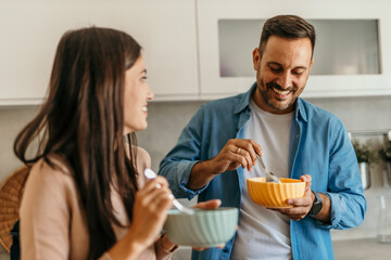 Happy couple enjoying breakfast together in modern kitchen