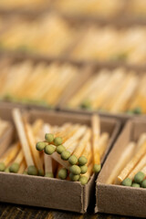 wooden matches with head in cardboard boxes closeup, the green head of a wooden match laid out in cardboard boxes