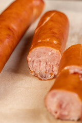 thin pork sausage fried in oil, sausages on food paper, close up