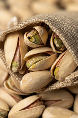 pistachio with salt in a linen bag, unpeeled pistachio nuts with cracked shells, poured into a coarse bag