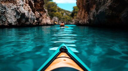 Kayak is seen floating on turquoise water between rock formations, with another kayaker visible in the distance.